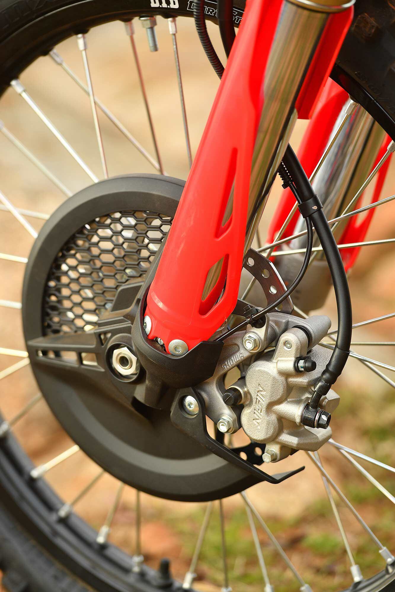 Red fork guards and the black disc cover protect the front end. The CRF450X-specific fork lug design is not only to enhance handling, but also to accommodate the speedometer.