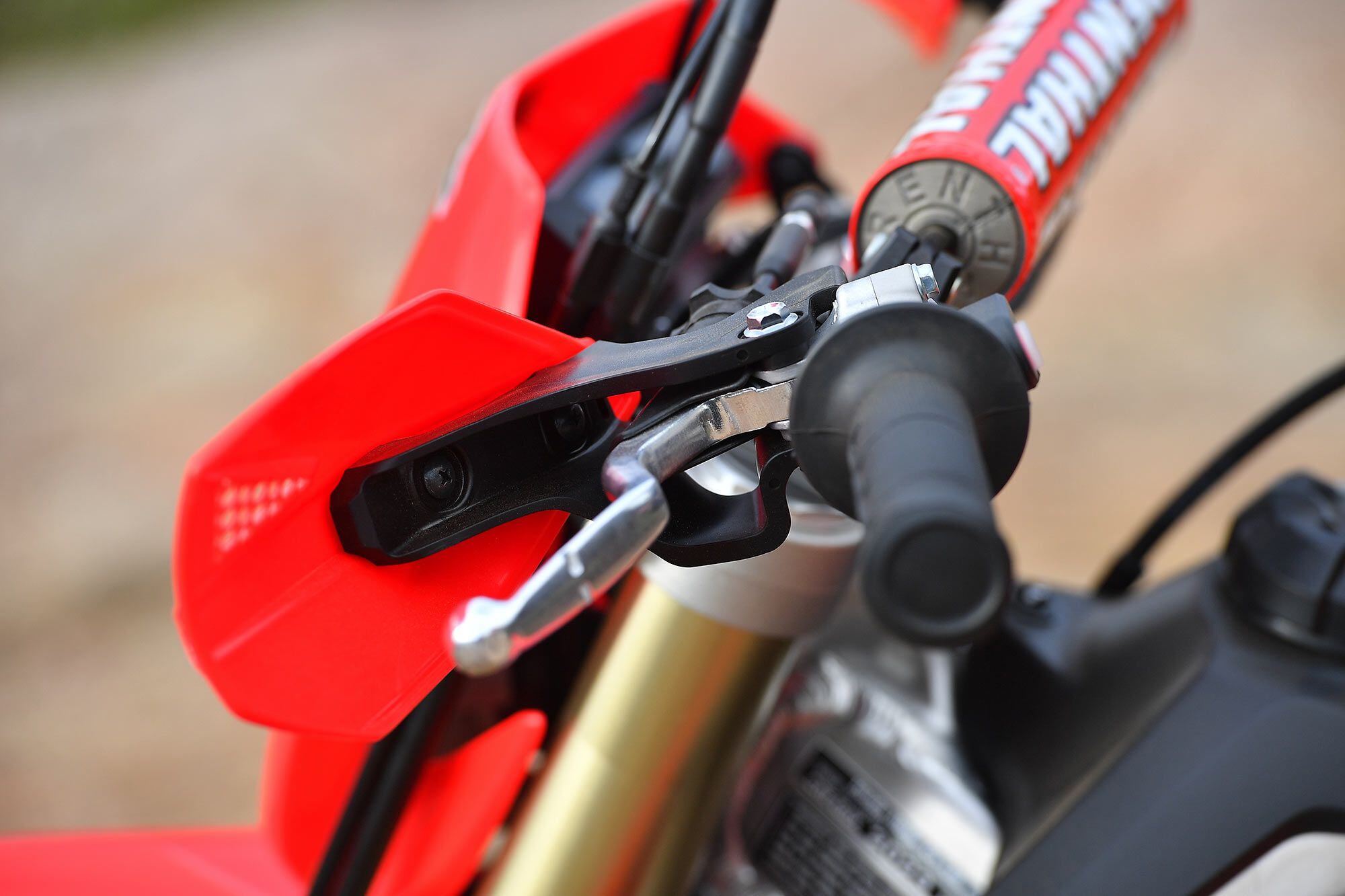 A cable-actuated clutch still comes standard on the CRF450X, where the CRF450R and CRF450RX machines receive hydraulic units. The hand guards are CRF450X-specific to fit the clutch perch and differing front brake master cylinder components.