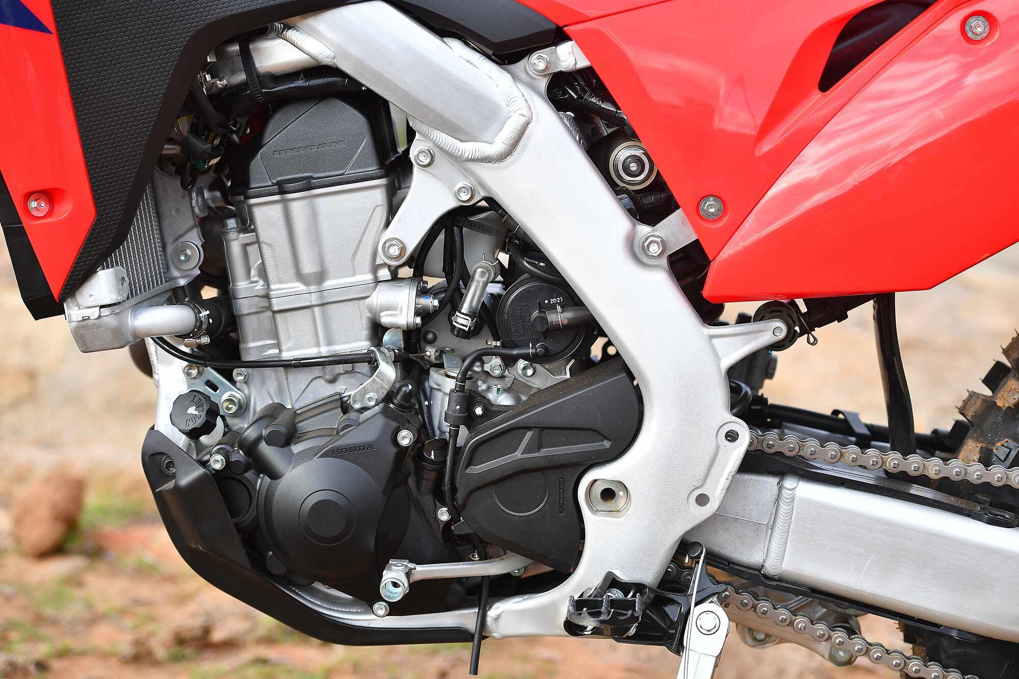 Left-side detail shot. The plastic ignition cover and countershaft sprocket guards are removable for those looking to simplify the design. The wide-ratio six-speed transmission means the CRF450X has the bones to go extremely fast, rider willing.