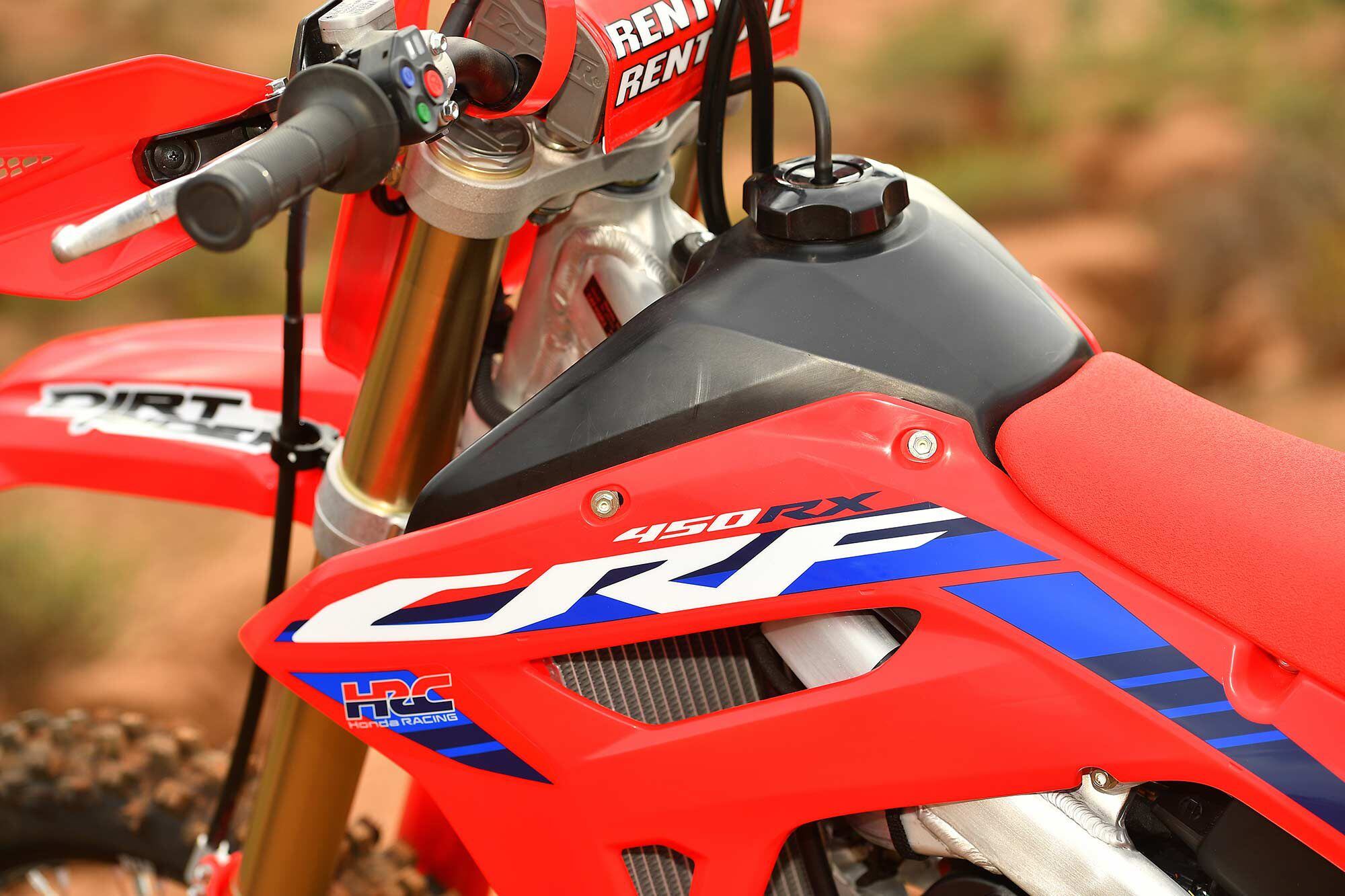 The 2.1-gallon resin fuel tank is sleek for its capacity, while the red/white/blue accents on the radiator shrouds look clean and factory. You can also catch a glimpse of the red/blue/green handlebar-mounted electronics switch here.