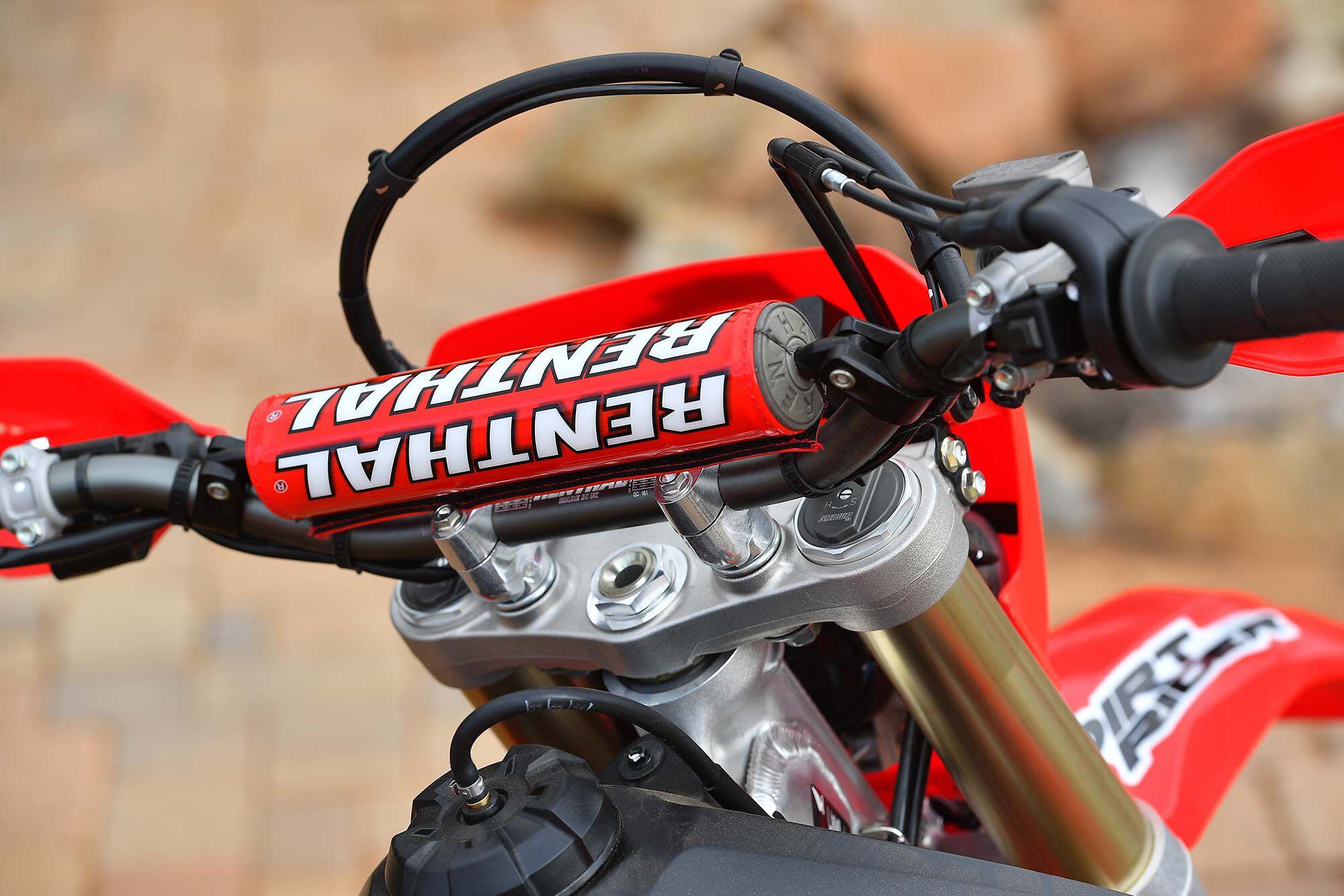 Renthal’s 7/8-inch-diameter handlebar graces the CRF450X. The 971-bend was a Honda staple for years, so Red Riders will feel right at home. Note the standard fork height placement (flush) with extended front brake line and speedo cable tied together.