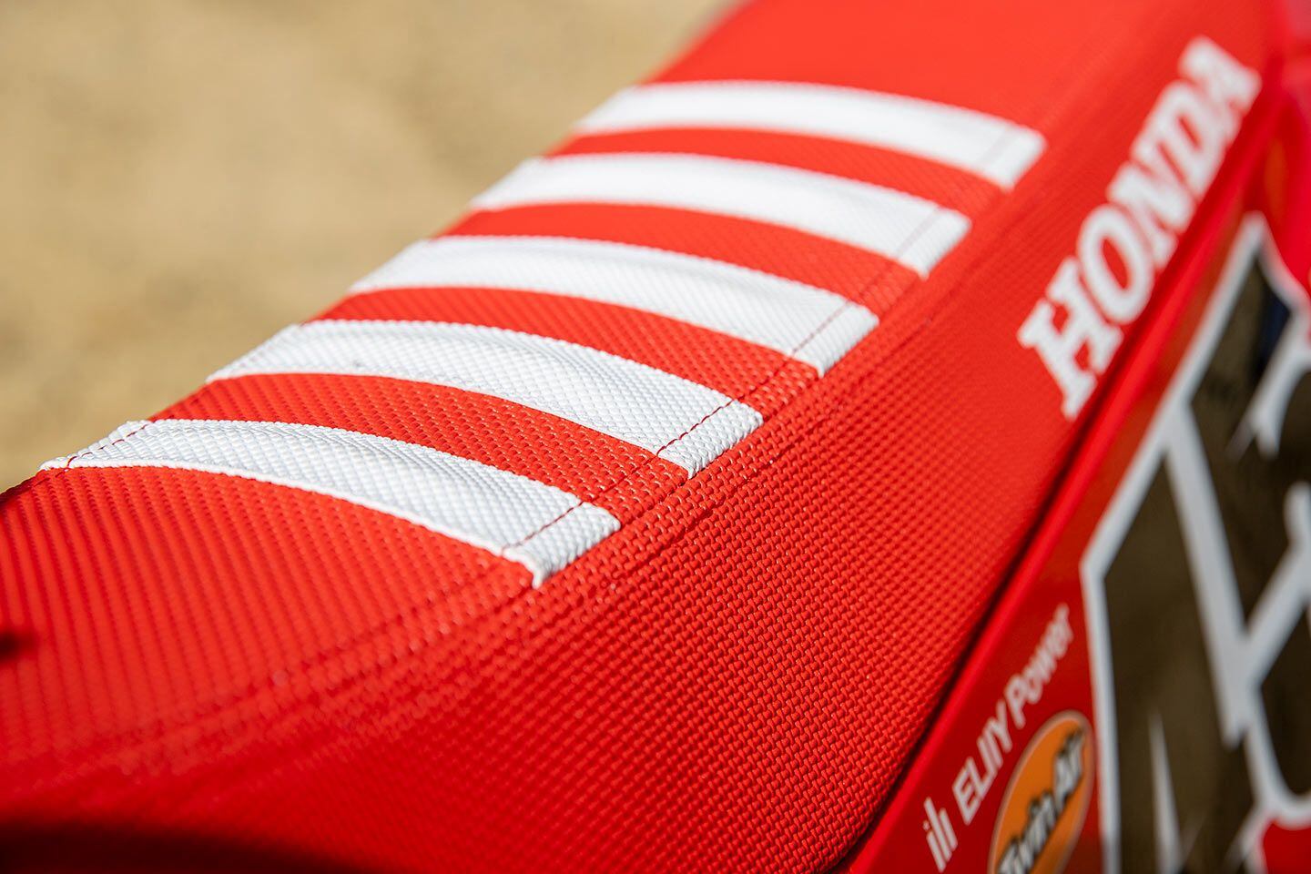 The red and white Throttle Jockey seat cover is perfectly installed and all but mandatory for the high torque and horsepower output of the CRF450RWE.