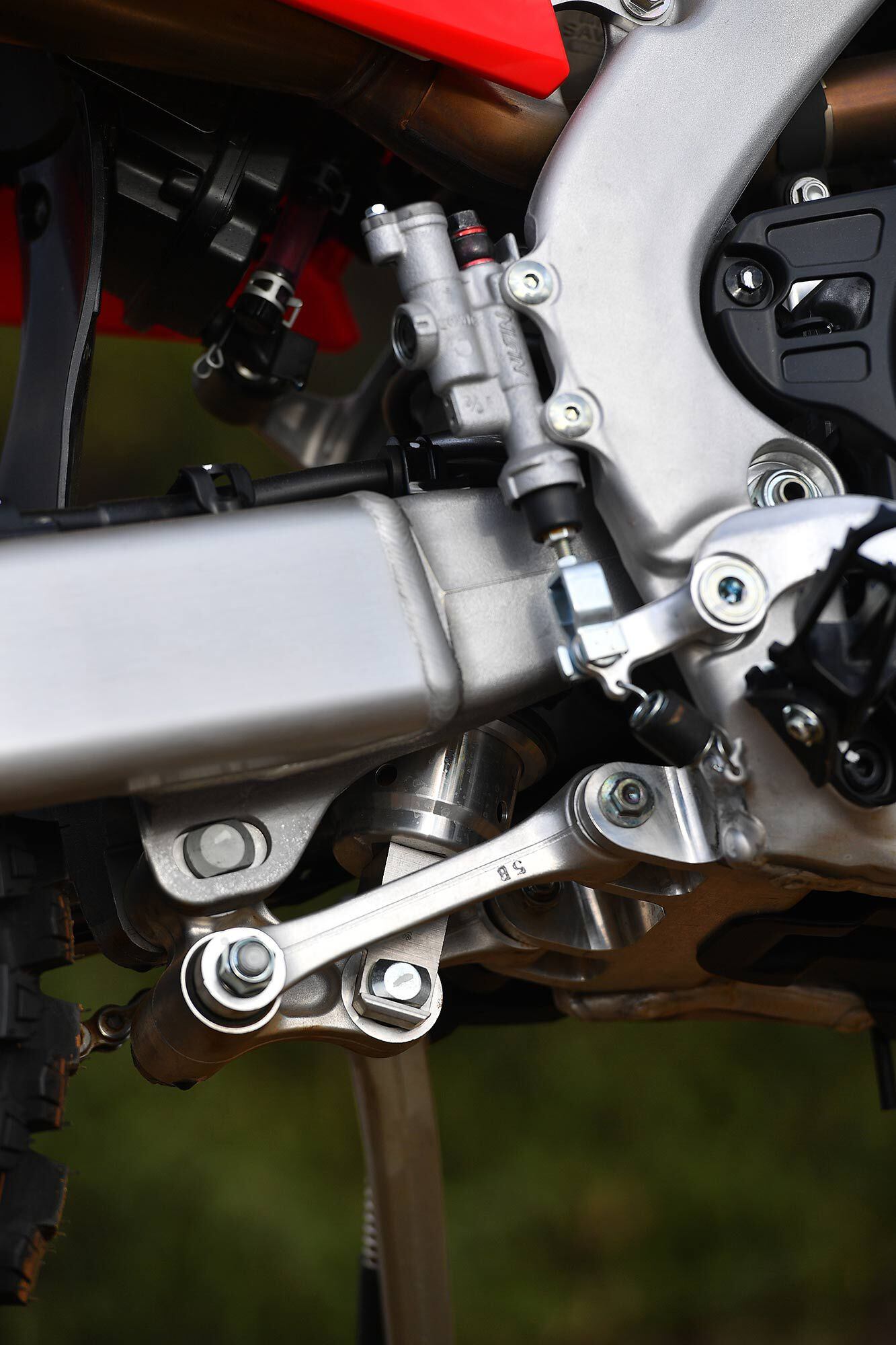 Lower right-side angle showing the linkage and rear brake master cylinder. Note the extended coverage of the black plastic clutch/case guard.