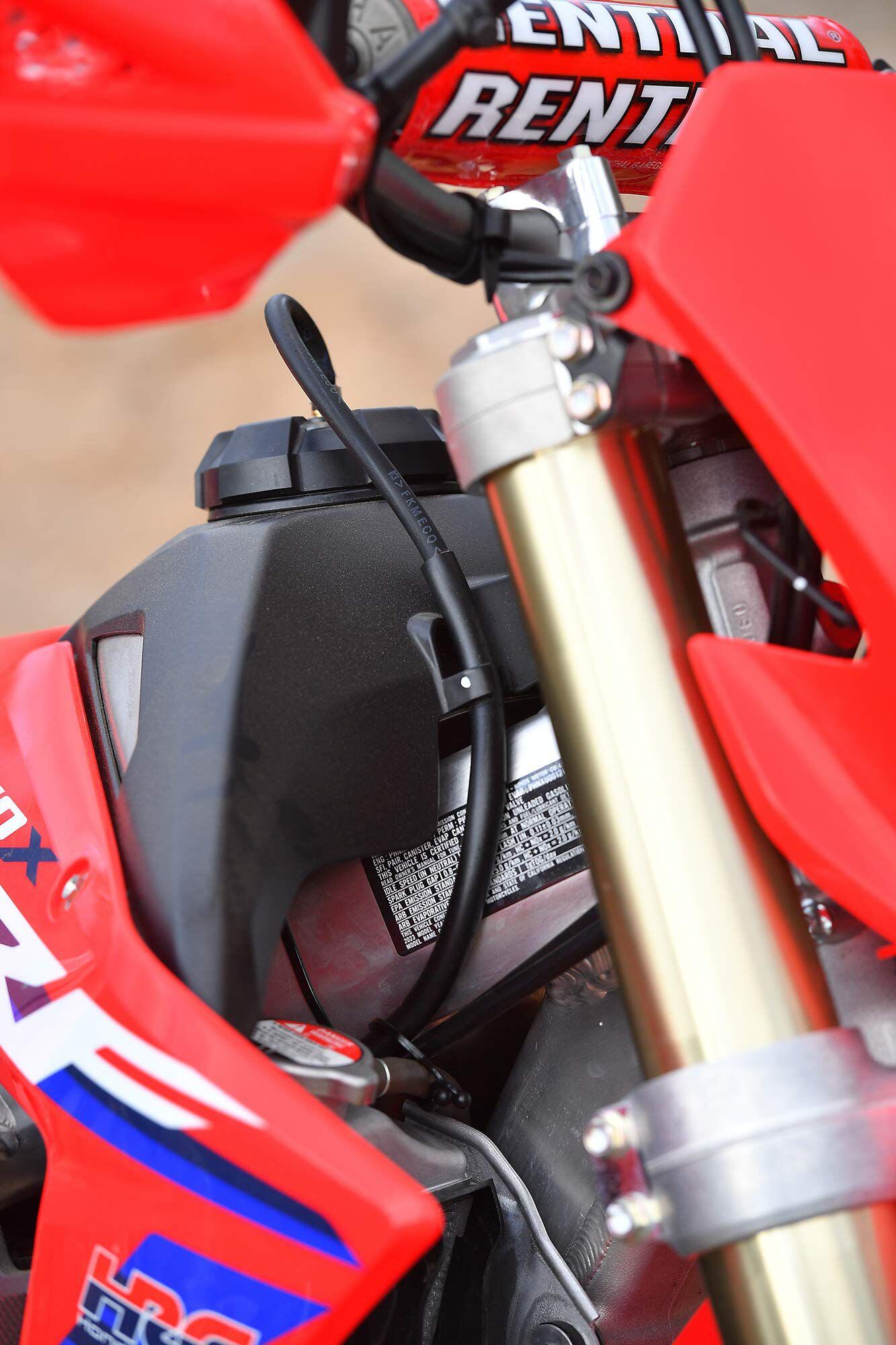 Titanium gas tank with black plastic protection. The overflow line never vents to the ground, just to a dedicated overflow canister.