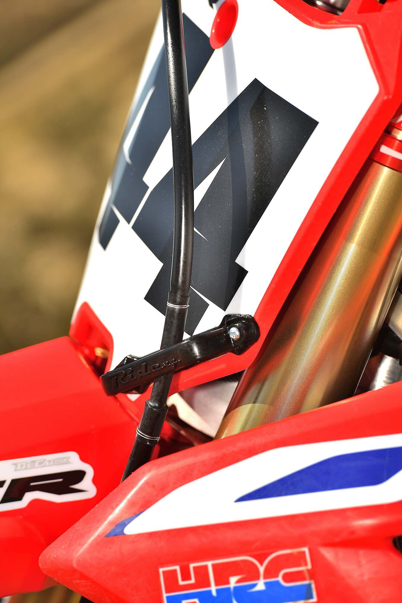 Because Ride Engineering’s triple clamps don’t allow for the use of a standard front brake line guide, one must be sourced through the aftermarket. Another option is to purchase a Cycra Stadium front number plate, which comes with one.